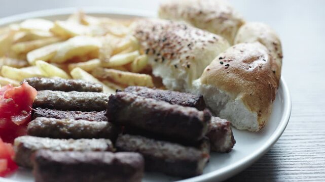 A balkan traditional meatball dish cevapi, cevapcici on wooden table in close-up

