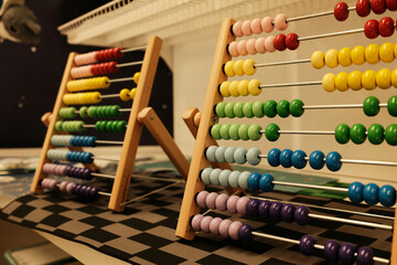 Colorful wooden abacuses with rainbow beads on display in a store, used for learning math and fine...