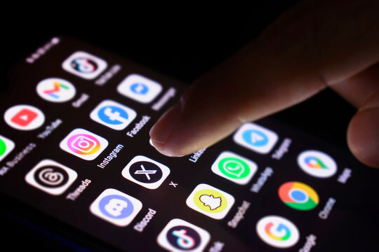 The phone screen is lit. Social media applications, touch the application X, 30 June 2025, Lopburi Province, Thailand.
