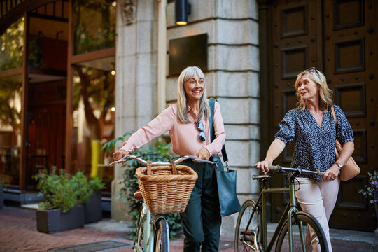 Happy senior women friends biking - Powered by Adobe