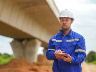 Caucasian young beautiful woman architect or builder in the hardhat standing at the roof of the...