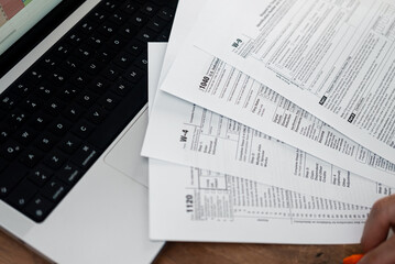 Business company accountant prepares for filling different tax forms indicating annual income...