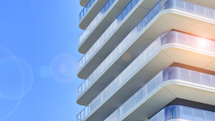 Exterior of a high modern multi-story apartment building - facade, windows and balconies.