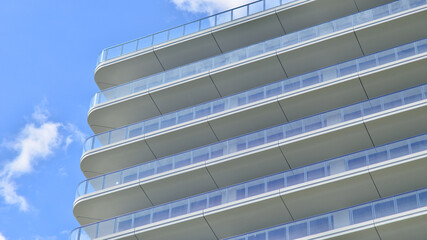 Exterior of a high modern multi-story apartment building - facade, windows and balconies.