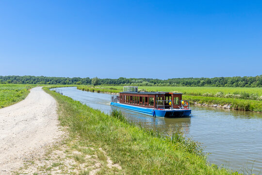 Pleasure boat navigating Bata Canal in Vnorovy, Czechia, during summer sunny day