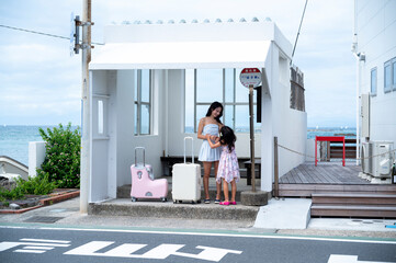 Mother and daughter waving at the seaside bus stop
