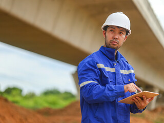 Asian engineer working with tablet at site of a large building project,Thailand people,Work...
