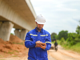 Asian engineer working with tablet at site of a large building project,Thailand people,Work...