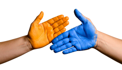 Two hands with colored paint, symbolizing diversity and unity, with one hand showing orange and the other showing blue.