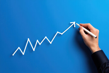 Illustrating Growth Trajectory A Hand Guides a White Arrow Upward on a Vibrant Blue Canvas Symbolizing Progress, Development, and Positive Trends in Business and Finance