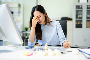 Asian woman feeling migraine head strain.Overworked businesswoman financier while working