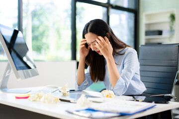 Asian woman feeling migraine head strain.Overworked businesswoman financier while working