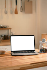 Naklejka premium Bright kitchen with a laptop, coffee, and a jar of dried fruit and warm natural light