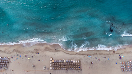 Aerial drone views of Falasarna Beach highlight its wide stretch of golden sand and vivid turquoise...
