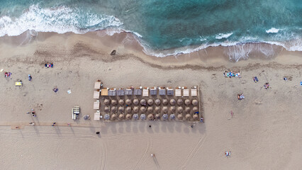 Aerial drone views of Falasarna Beach highlight its wide stretch of golden sand and vivid turquoise...