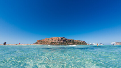 From the viewpoint above Balos Lagoon, the sweeping view reveals turquoise waters, the narrow sandy...
