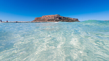 From the viewpoint above Balos Lagoon, the sweeping view reveals turquoise waters, the narrow sandy...