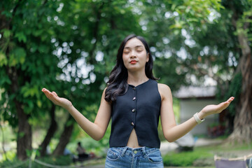 Young woman practicing yoga meditation in peaceful green park