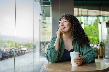 Young woman enjoying coffee in a bright cafe setting