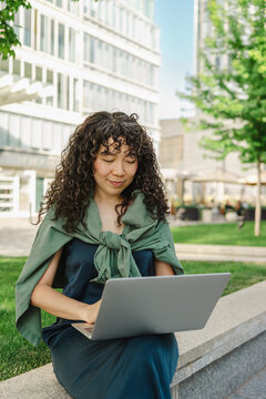 Young woman working on laptop outdoors