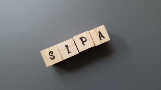 SIPA acronym made of wooden letter cubes on dark background. Sistema de Pensiones Auton&oacute;mico (Regional Pension System)