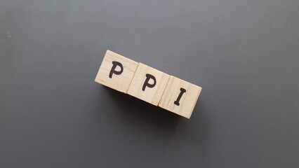 PPI acronym made of wooden letter cubes on dark background. Plan de Previsión Individual...