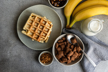 Breakfast with chocolate cereal and milk on table