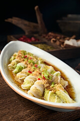 Chinese food: Steamed cabbage and pork rolls with garlic, rice and pepper