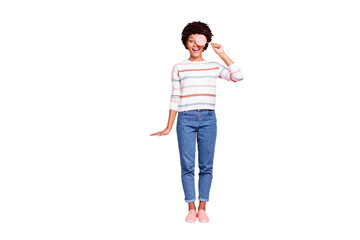 Full length body size photo of childish girlish curly wavy trendy stylish girlfriend holding candy wearing jeans denim footwear white striped sweater isolated over pink pastel color background