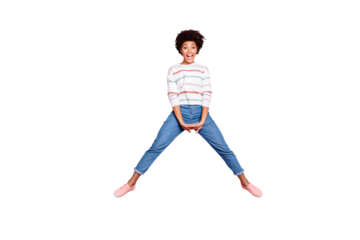Full length body size photo of cute nice black woman jumping up doing splits with hands folded expressing joyfulness with face in jeans denim sweater isolated over pink pastel color background