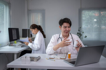 Fototapeta premium man in a white lab coat is talking on a laptop computer