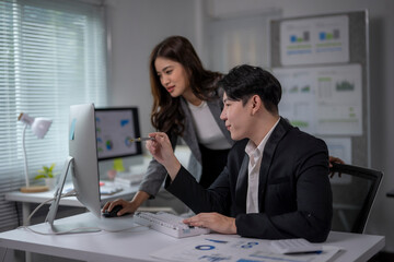 man and a woman are working together on a computer
