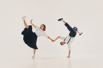 Dancers perform an energetic lindy hop routine with acrobatic moves on a plain white background....