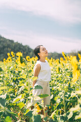 Solitude and freedom woman standing relax in sunflower botanical field park outdoors with sunlight