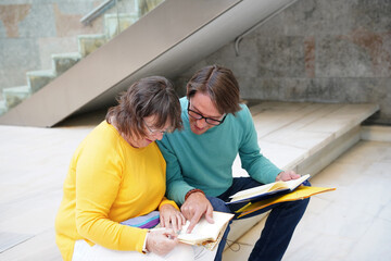 Elderly teacher and student learning outdoors together