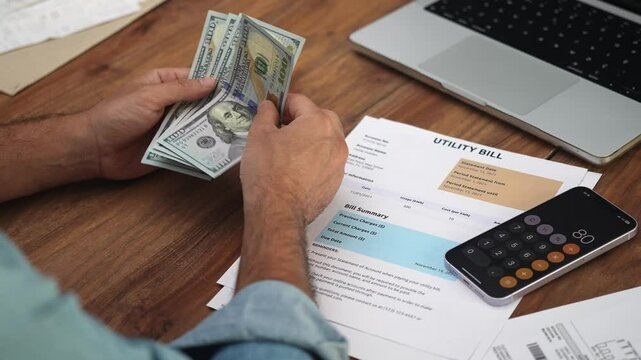 Middle aged man holds stack of dolla rbanknotes in hands calculating total amount, businessman computes number of banknotes required to settle bills slow motion