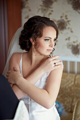 A woman in a wedding dress is wearing a black and white wedding band. She is standing in front of a...