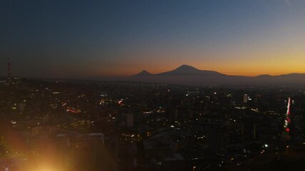 Drone shot Yerevan in night time. Drone view Mother Armenia statue in Victory Park in evening time.  High angle view of illuminated buildings in city at night, Yerevan, Armenia, West Asia. 