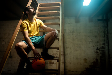 A determined basketball player, confidently poised with a ball in hand, is captured in a dynamic...