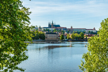 A tree framed view from the east bank towards the castle complex in Prague in springtime