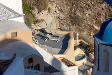 Whitewashed houses with terraces and pools and a beautiful view in Oia on Santorini island, Greece