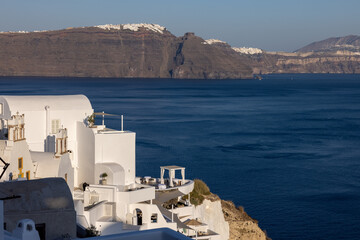 Whitewashed houses with terraces and pools and a beautiful view in Oia on Santorini island, Greece