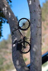 Miniature vintage bicycle decor pinned on tree trunk