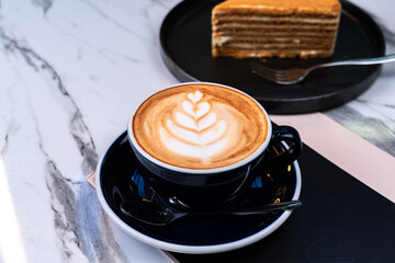 Latte coffee with honey cake and blurred background