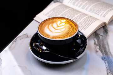 Latte coffee with open book on marble table