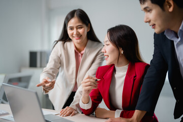 Group of happy diverse businesspeople working and collaborating discussing using laptop computer at...