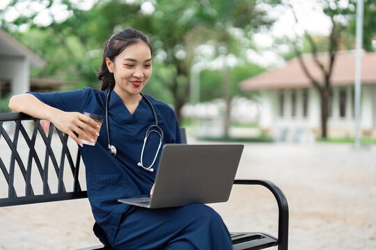 Doctor using laptop outdoors. Healthcare professional engaging in telemedicine consultation.
