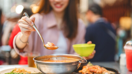Traveller woman enjoy eating street food spicy thai tasty menu travel at chinatown Yaowarat, Bangkok, Thailand