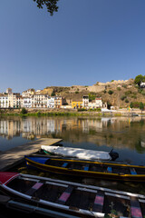 Colorful boats resting on the shore of the Ebro River in Mora d'Ebre, Catalonia