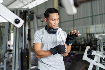 Gym Preparation. Man adjusting wrist wraps before workout.